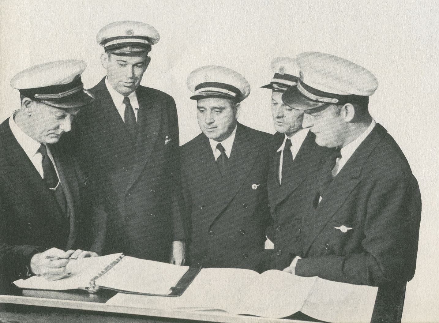 1956 Pan Am pilots gather before a flight to discuss weather and the route plan.  Pilot Victor Grubbs is second from left.